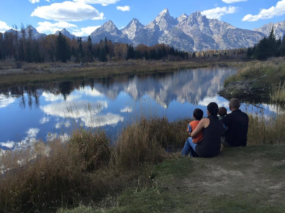 Arcel's family by the water, the Teton range behind